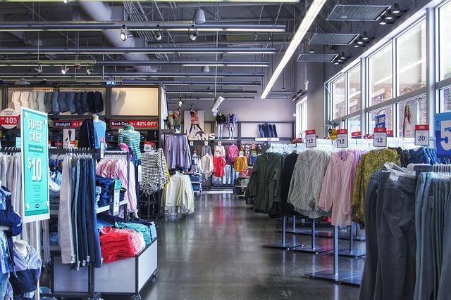 racks of clothes in a large department store.