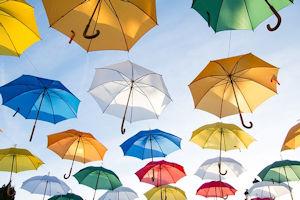 several colorful umbrellas floating in the sky