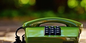 A sleek bright green retro phone with square push buttons to dial.