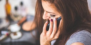 Side view of a young woman on the phone.